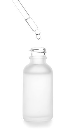 Dripping of serum from pipette into bottle on white backgroundの写真素材