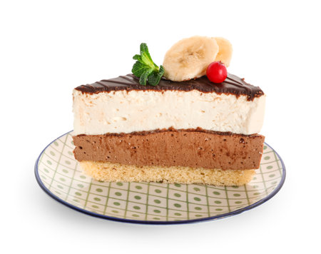 Plate with pieces of birds milk cake, banana slices and mint leaves on white backgroundの写真素材