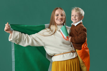 Beautiful woman with her little son and flag of Ireland on green backgroundの写真素材