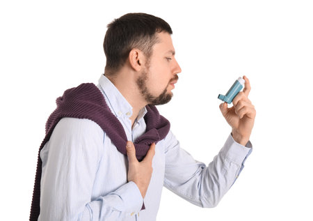 Sick man with inhaler on white backgroundの写真素材