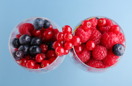 Glasses of fresh berries on color backgroundの写真素材