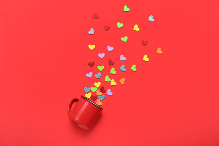 Cup with colorful hearts on red background. Valentine's Day celebrationの写真素材