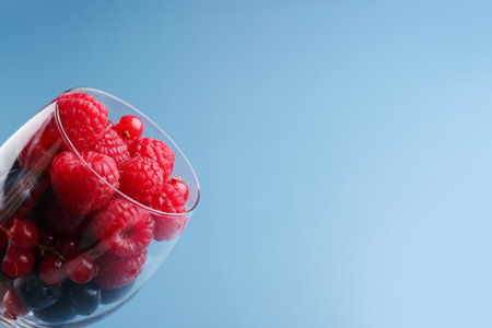 Glass of fresh ripe berries on color background, closeupの写真素材