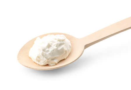 Wooden spoon with tasty cream cheese on white background, closeupの写真素材