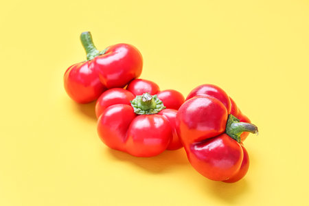 red bell peppers on yellow backgroundの写真素材