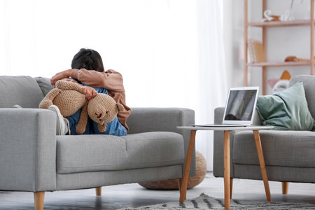 Upset little boy with toy video chatting at homeの写真素材