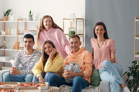 Group of friends with pizza spending time together in living room