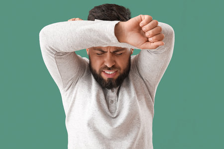 young man worrying on green background