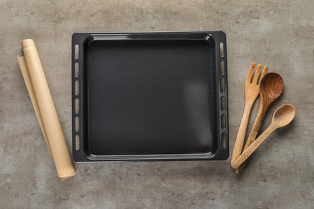 Baking tray with parchment paper and spoons on grunge backgroundの写真素材