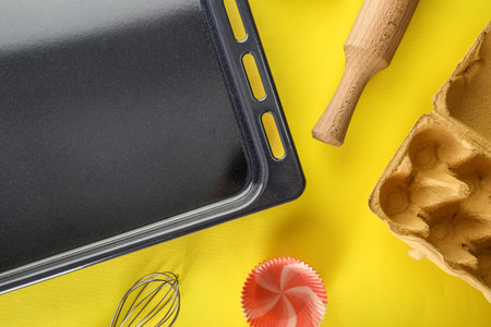 Baking tray with utensils on yellow backgroundの写真素材