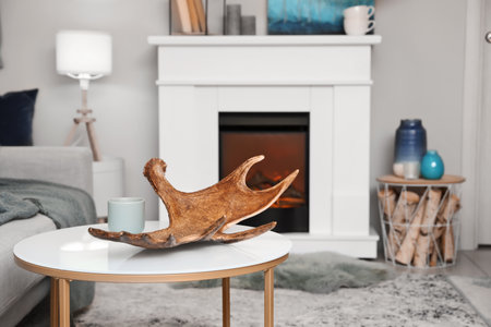 Moose antler on table in interior of room with fireplaceの写真素材