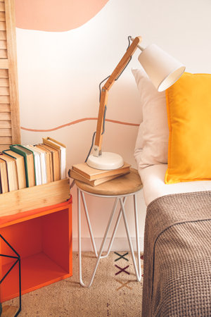 Table with lamp in interior of stylish bedroomの写真素材