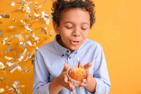 African-American boy celebrating birthday on color background