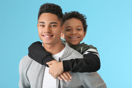 Portrait of African-American brothers on color backgroundの写真素材