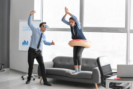 Colleagues with inflatable ring and snorkeling mask having fun in officeの写真素材