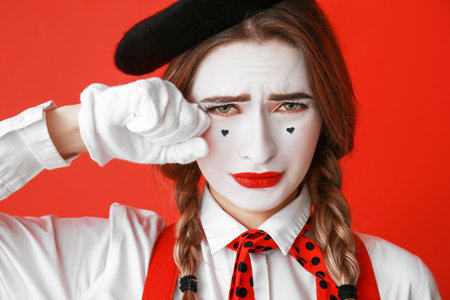 Crying female pantomimist on color backgroundの写真素材