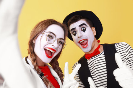 Male and female pantomimists on color backgroundの写真素材