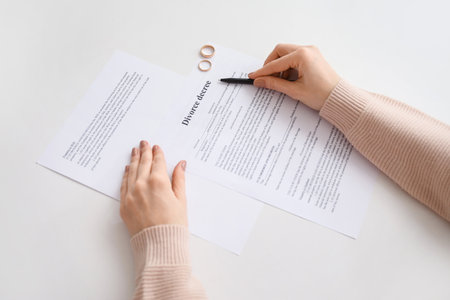 Woman with divorce decree and rings in lawyer's office, closeupの写真素材