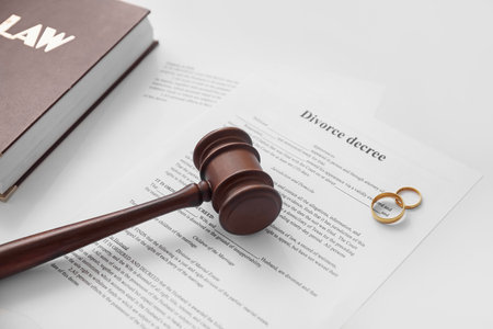Divorce decree with judge's gavel and rings on white backgroundの写真素材