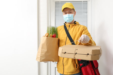 Courier of food delivery service near customer's doorの写真素材