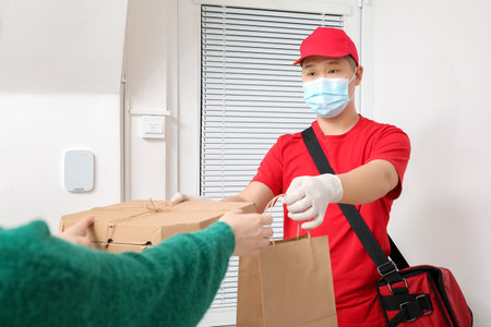 Woman receiving her order from courier of food delivery service