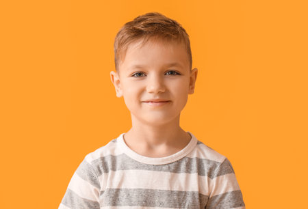 Cute little boy on color background