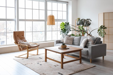 Interior of modern living room with gray sofa, armchair and palm tree