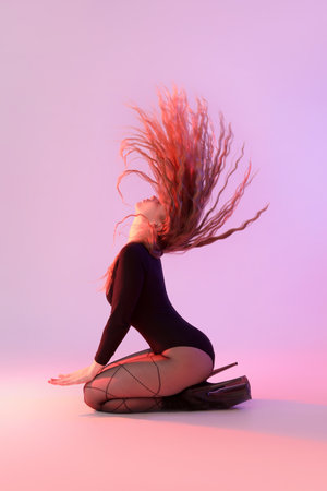 Attractive female dancer in high heels on color backgroundの写真素材