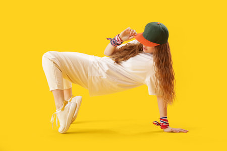 Female hip-hop dancer on yellow backgroundの写真素材