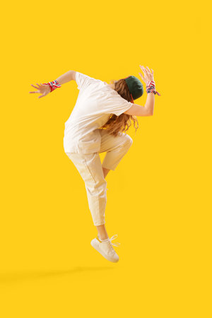 Female hip-hop dancer on yellow background
