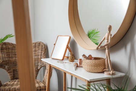 Table with mirror, brushes, cosmetics and wooden mannequin in makeup roomの写真素材