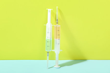 Medical syringes with remedy on color background