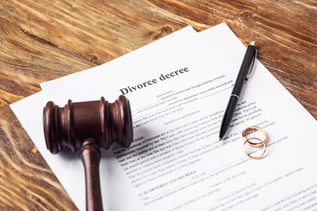 Divorce decree with judge's gavel and rings on wooden backgroundの写真素材