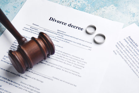 Judge's gavel, rings and divorce decree on color background