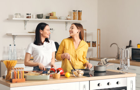 Young lesbian couple cooking dinner in the kitchenの写真素材