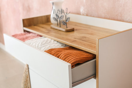 Stylish chest of drawers with clothes in room, closeupの写真素材