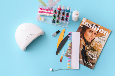 Set of professional tools for manicure, nail polishes and magazine on color backgroundの写真素材