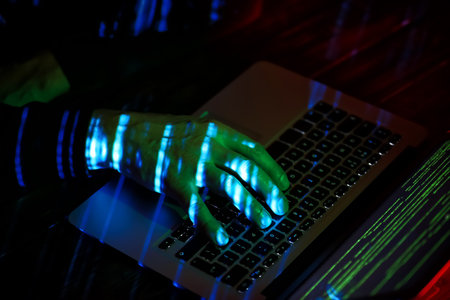 Hacker using computer in dark roomの写真素材