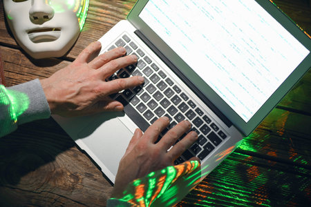 Hacker using computer in dark roomの写真素材