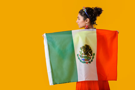 Young beautiful woman with Mexican flag on color backgroundの写真素材