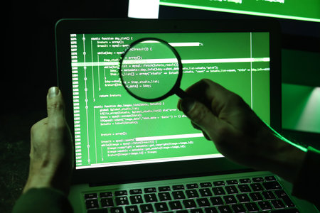 Hacker with magnifier using computer