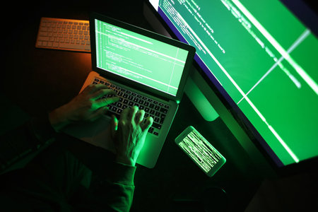 Hacker using computer in dark room