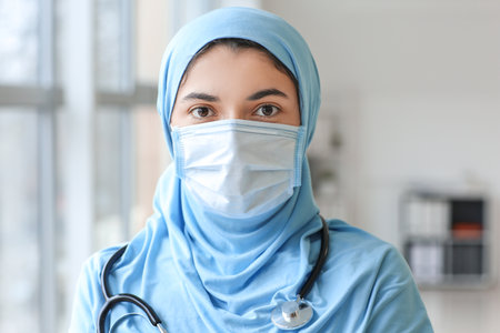 Portrait of female Muslim doctor wearing protective mask in clinicの写真素材