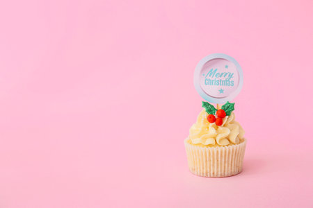 Tasty Christmas cupcake on color backgroundの写真素材