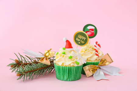 Tasty Christmas cupcakes and decor on color backgroundの写真素材