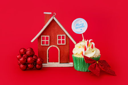 Composition with tasty Christmas cupcake and decor on color backgroundの写真素材