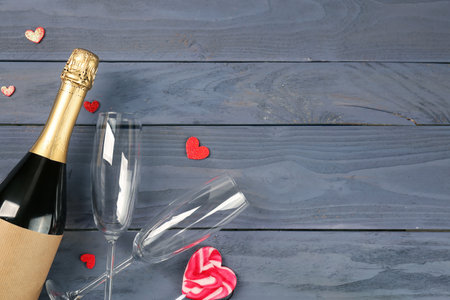 Bottle of wine, glasses and heart-shaped lollipop on wooden background. Valentine's Day Celebrationの写真素材