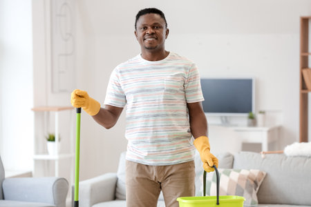 African-American man cleaning his flatの写真素材