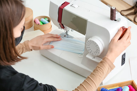 Female tailor making protective masks in workshopの写真素材