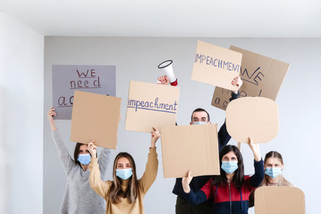 Protesting people indoors near white wall. impeachment conceptの写真素材